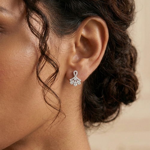 Close-up of an ear wearing a silver diamond earring with a blurred background
