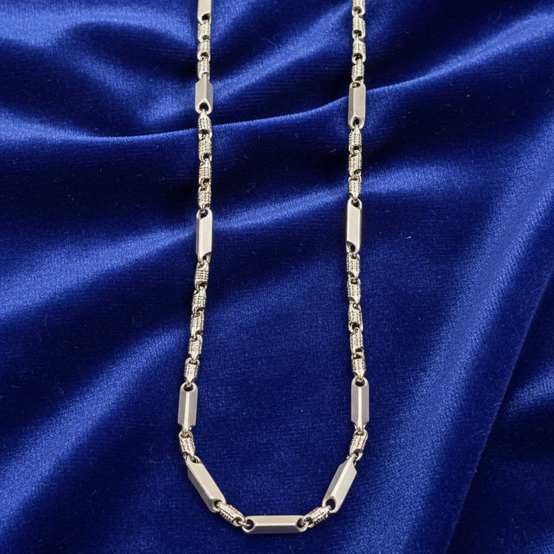 Silver chain necklace on a blue satin background