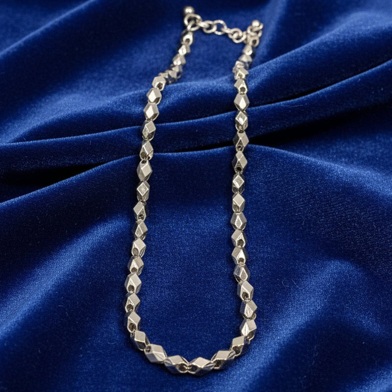 Silver chain necklace on a blue satin background