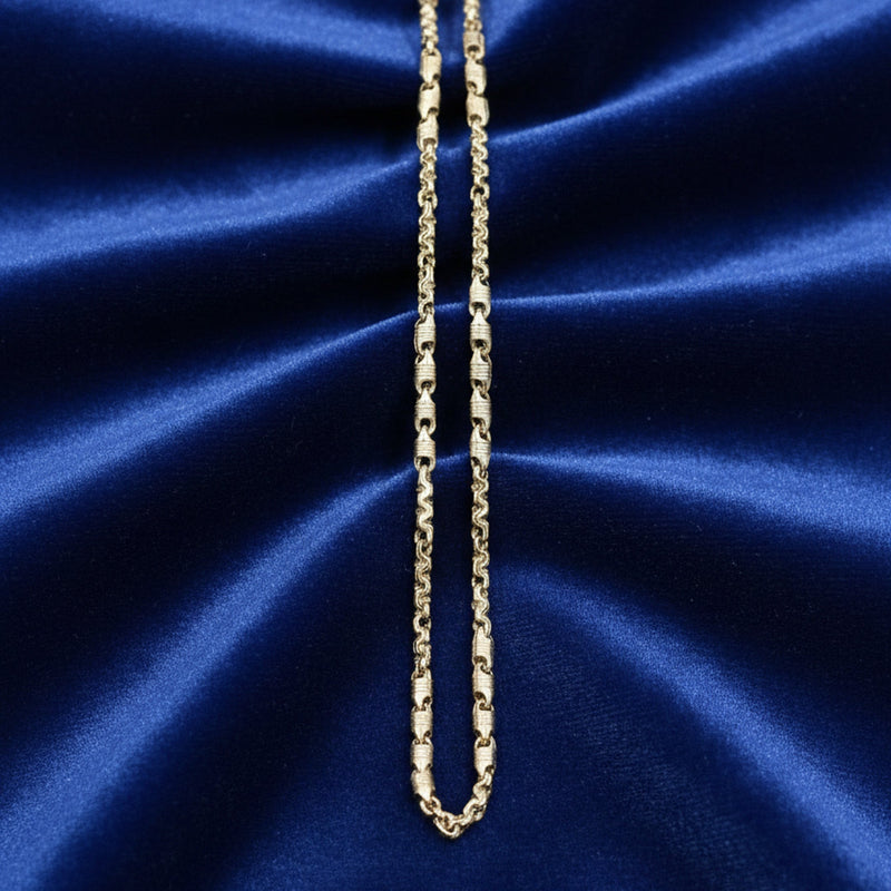 Gold chain necklace on a blue satin background