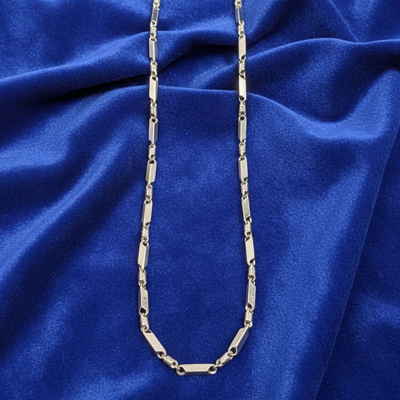 Silver chain necklace on a blue fabric background